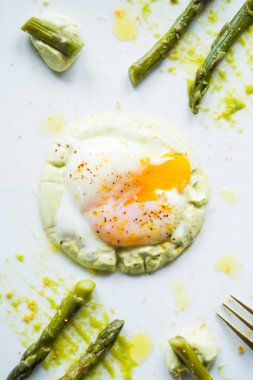 Sous vide haşlanmış yumurta mükemmel tutarlılık için 64,5 derece pişmiş, bir kuşkonmaz püresi ve kuşkonmaz kökleri ile bir çanak dikdörtgen beyaz, düz, üst görünümü, gurme gıda