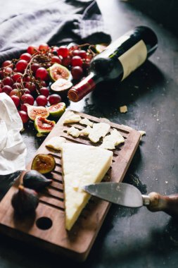 Sonbahar gıda natürmort, üzüm, elma, incir, pecorino peyniri ve kırmızı şarap bir şişe, kutlama üzüm harvey ve sonbahar sezonu, üst görünümü, karanlık ruh hali düşük anahtar aydınlatma, üst görünümü