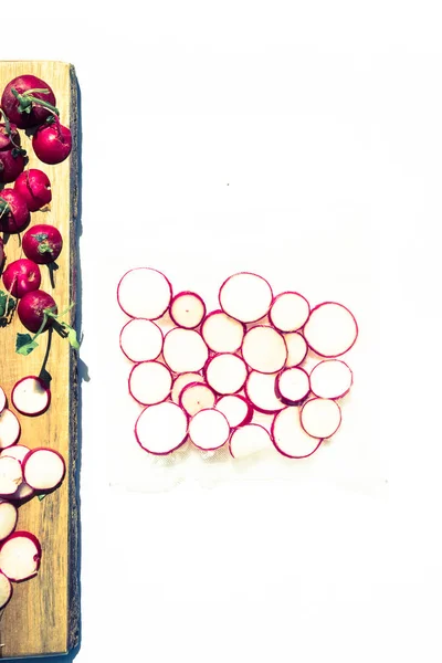 Radishes vacuum sealed on a plastic bag,on a white board sliced on a cutboard
