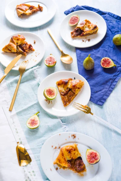 Figs galette made with pastry crust and fresh fig on a dish over a wooden board, top view.