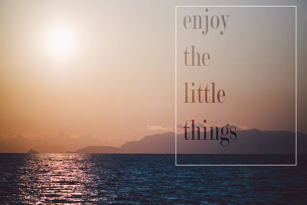 Amazing sunset on a seascape, with the quote enjoy the little things   text on layer,