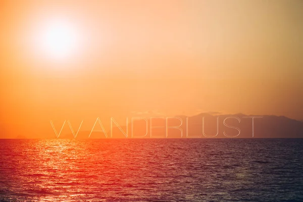 Atemberaubender Sonnenuntergang Auf Einer Meereslandschaft Mit Dem Wort Fernweh Text lizenzfreie Stockbilder