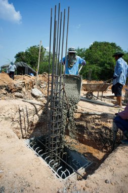 İşçiler carrys çimento cart ve yapım aşamasında evin temeli dökmek