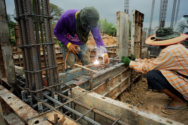 Workers welding the steel for supporting the mold of concrete structure at the construction site