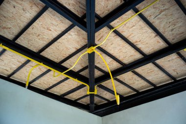 Elektrik sarı boru yapım aşamasında evde çelik çatı yapısı üzerinde yükleme altında