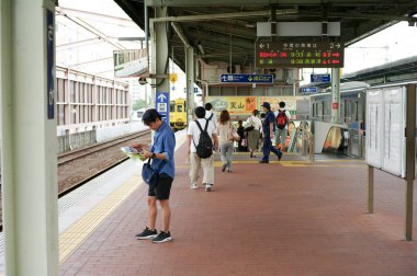 Saga, Japonya: Eylül 1, 2016 - portre Asya adam ayakta ve Saga, Japonya'nın seyahat sırasında haritaya tren istasyonu platformu