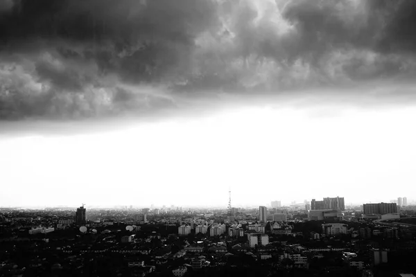 Monochrome landscape of city with crowd of building and residential area with rainy cloud