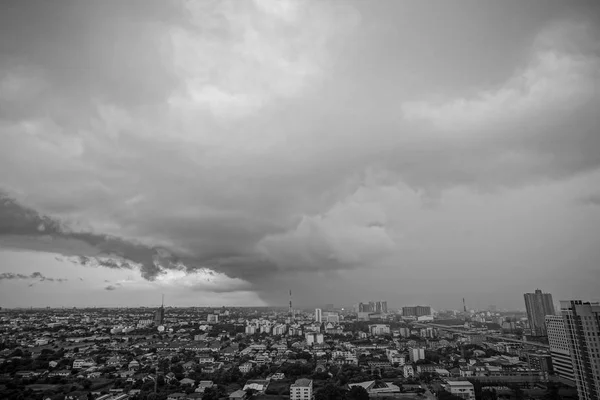 Monochrome landscape of city with crowd of building and residential area with rainy cloud