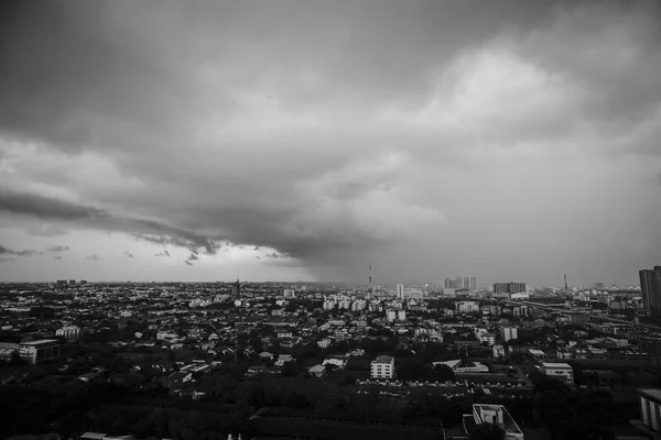 Monochrome landscape of city with crowd of building and residential area with rainy cloud