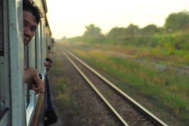 Chacheangsao, Tayland: Aralık 5, 2018 - portre portre adam kameraya bulanık parça ve doğal arka plan manzara ile tren penceresini dışarıdan bakan