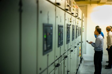 Kontrol odasında önleyici bakım yapan teknisyenin bulanık portresi. Kontrol listesine göre elektronik aygıtların durumunu izleyen işçiler.