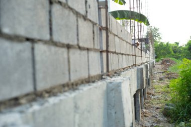 Şantiye beton çimento duvar ve tuğla duvar arka planda yükleme alt el ile peyzaj