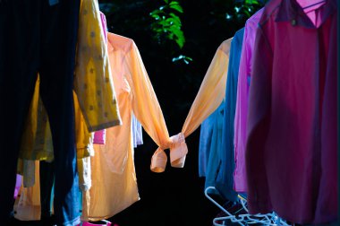 Renkli ıslak giysileri güneş ısı ile kurutma için çelik clothesline asılı. Tatlı çift gömlek kavramının. Mutlu sevgililer günü