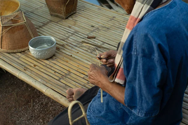 有选择地关注老人的手 通过编织天然材料制作传统的篮子 — 图库照片