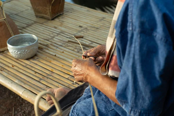 有选择地关注老人的手 通过编织天然材料制作传统的篮子 — 图库照片