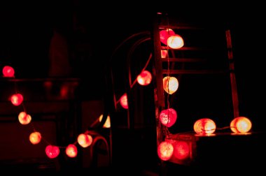 Karanlık odaya dekore edilmiş ahşap sandalye asılı led ışıklar çizginin closeup kalp şeklini