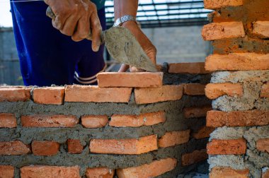 Closeup doku ve arka plan inşaat sahasında işçi tarafından yüklü turuncu tuğla örme ustaları