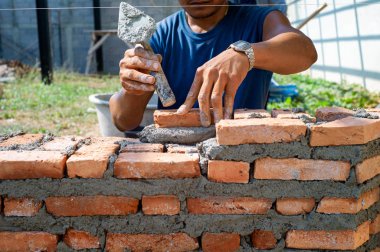 Closeup doku ve arka plan inşaat sahasında işçi tarafından yüklü turuncu tuğla örme ustaları