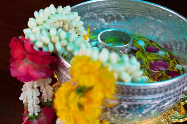 Closeup flower garlands hanging on the edge of silver bowl with — Stock Photo, Image