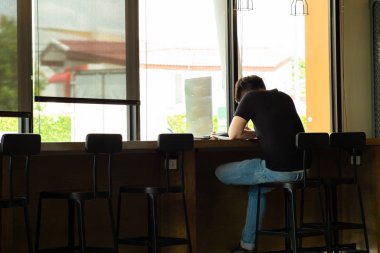 Arka portre Asyalı genç adam kahve dükkanında çalışıyor
