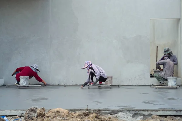 Back portrait group of workers use trowel for flooring the cement — Stock Photo, Image