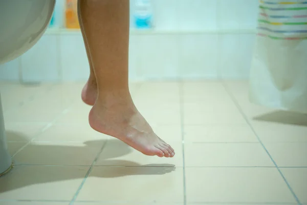 Closeup legs and feet of child siting and peeing in toilet — Stock Image Closeup legs and feet of child siting and peeing in toilet Stock Image