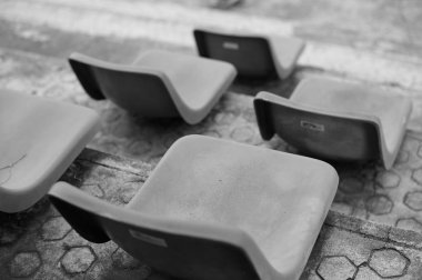 Plastik sandalye sıraları üzerinde seçici odak Monokrom resim 