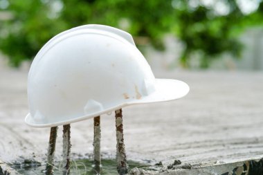 Terk edilmiş şantiyedeki beyaz kaskla kaplanmış paslı takviye çelik.