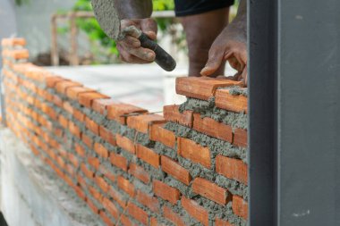 Kapalı kırmızı tuğla ustaları duvar ve kirli işçilik geçmişi olan mala.
