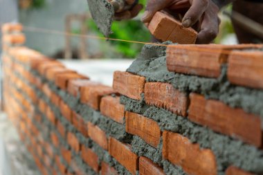 Kapalı kırmızı tuğla ustaları duvar ve kirli işçilik geçmişi olan mala.