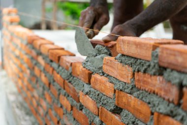 Kapalı kırmızı tuğla kaplama duvar ve çimento teektürü hareket bulanık el ve arka planda mala