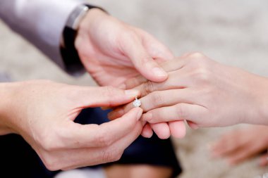 Nikah yüzüğü takan damat ve gelinin yakın çekimleri. Nişan için elmas yüzük