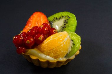 Taze biyo meyve, portakal, kivi, frenk üzümü, çilek, yan görünümü fotoğraf, siyah arka plan ile pasta