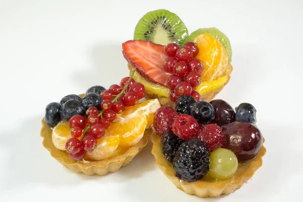 Three cakes with fresh bio fruits, orange, kiwi, strawberries, blueberries, red currants, grapes, raspberries, blackberries, side photo, white background, isolate — Stock Photo, Image