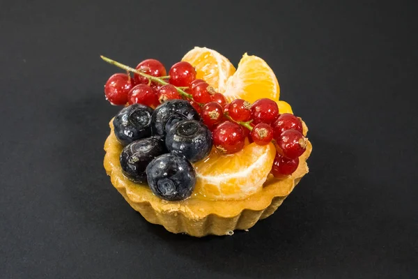Cupcake con frutas frescas bio, naranja, arándano, grosella roja, vista lateral foto, fondo negro — Foto de Stock