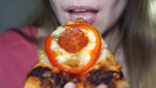 Chica muerde una rebanada de pizza — Vídeo de stock
