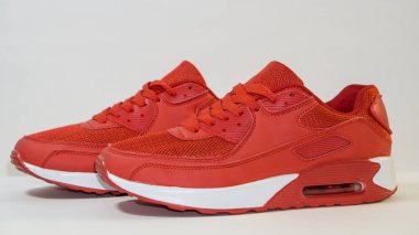 Beyaz bir arka planda, kırmızı spor ayakkabıları, beyaz taban ile, bir gölge, yakın çekim