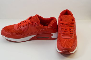 Beyaz arka planda beyaz taban ile kırmızı spor ayakkabıları, yakın çekim