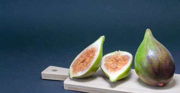 Green figs, one fruit cut into two halves.
