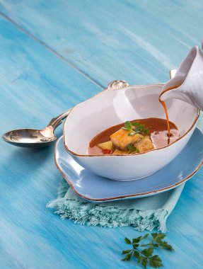 Mavi arka planda balık çorbası ve kaşık