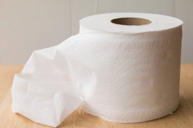 Ahşap masa üzerinde beyaz kağıt rulosunun yakın.