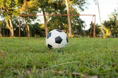 Çocuk spor sahasında futbol topunu tekmeliyor. Çocuklar için futbol antrenmanı.