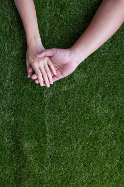 El ele tutuşan aşıklar çift yeşil suni çim valen üzerinde kalmak