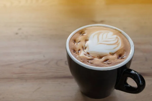 Tutup cangkir kopi seni latte panas di atas meja kayu. — Stok Foto