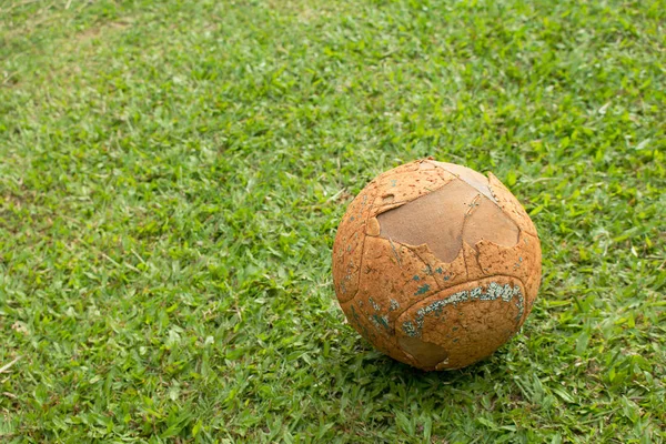 Старый футбольный мяч на футбольном поле . — стоковое фото