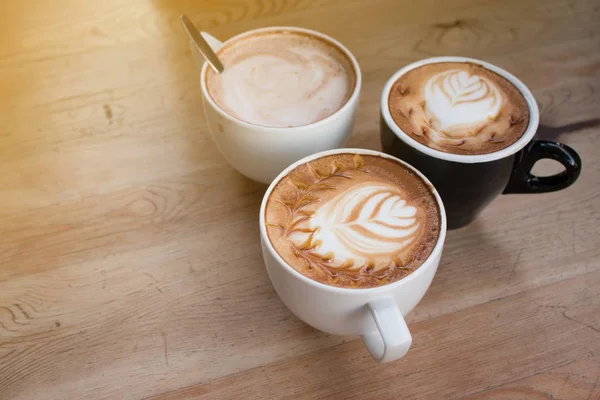 Primer plano de la taza de café latte arte caliente en la mesa de madera. — Foto de Stock