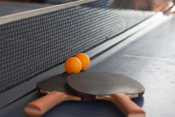 Close up orange ball with table tennis racket  on black table.