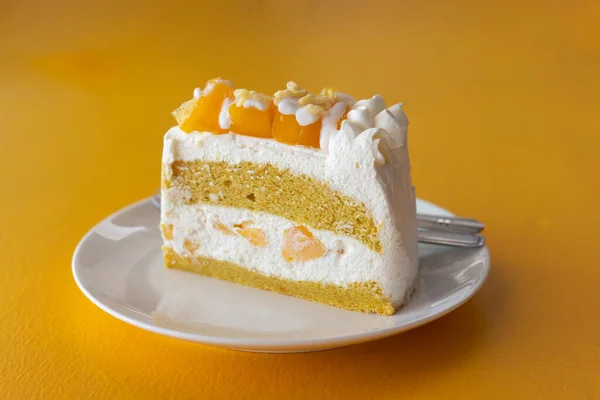 Yaz meyveli tatlı, sarı masa arkasında mango peynirli kek..