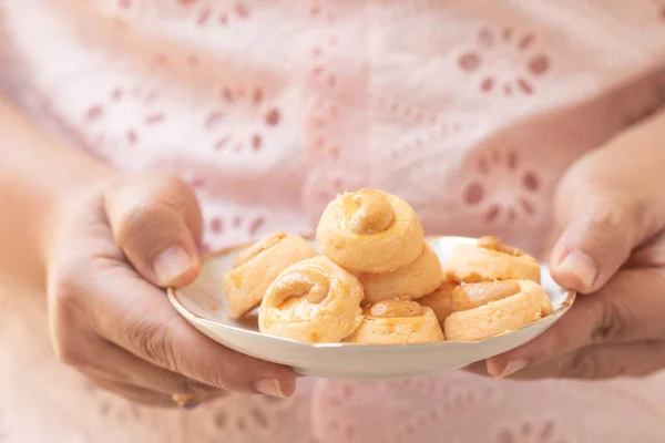 Hand holding Cookies Singapore or cashew Cookies.