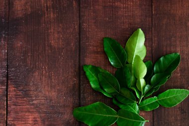 Taze Yeşil Kafir Kireç Yaprakları ahşap masa arkasında, Asya 'nın yiyecekleri için fotokopi alanı içeriyor..